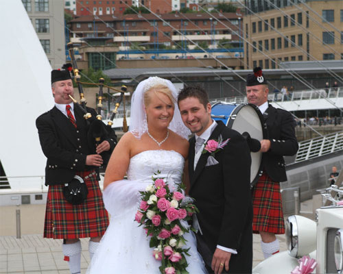 bride and groom listening to the pipes